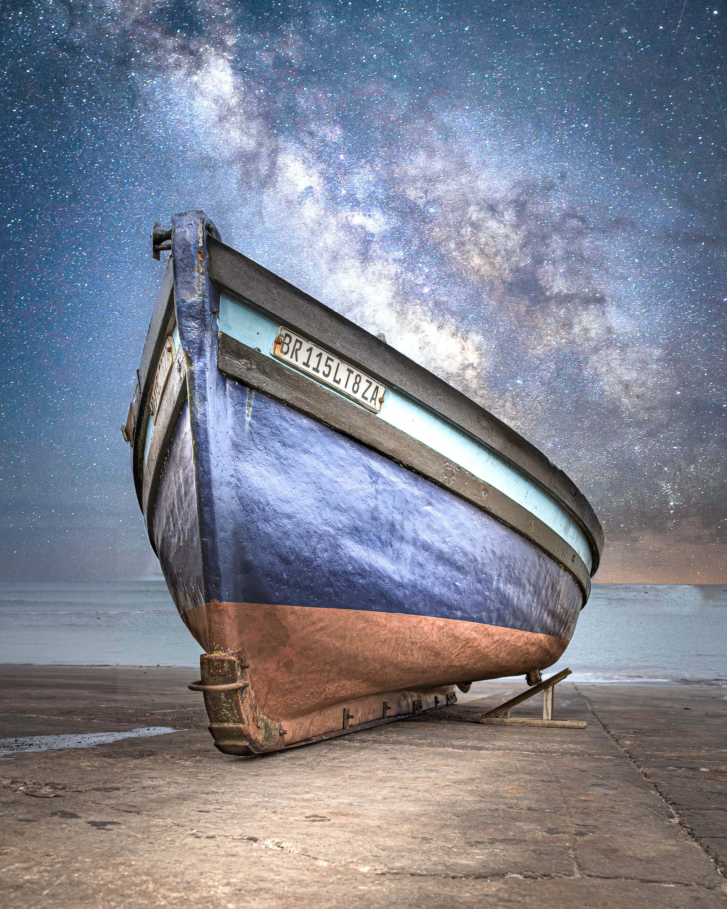 Rustic wooden boat on a wooden deck with a starry night sky background